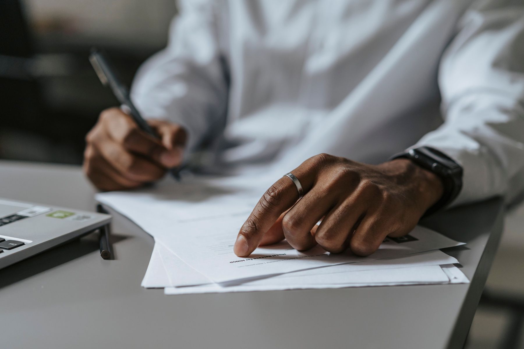 Hand signing off a document at a desk